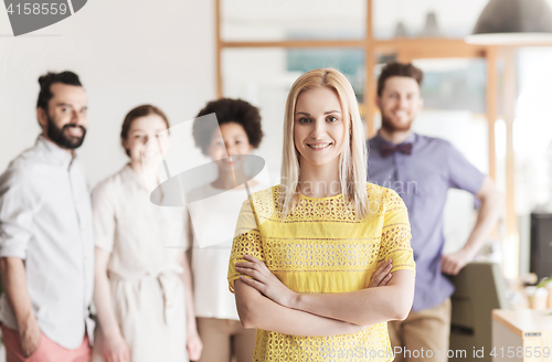 Image of happy young woman over creative team in office