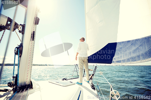 Image of senior man on sail boat or yacht sailing in sea