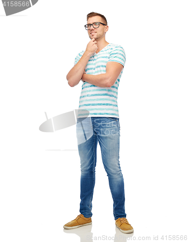 Image of smiling young man in eyeglasses thinking