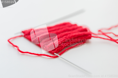Image of hand-knitted item with knitting needles