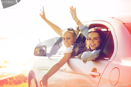 Image of happy teenage girls or women in car at seaside