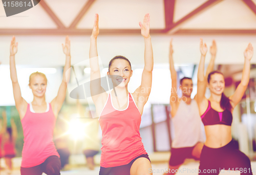 Image of group of smiling people exercising in the gym