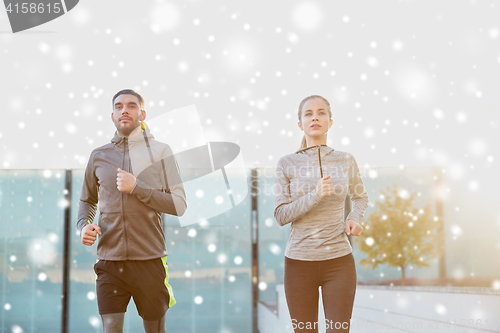 Image of happy couple of sportsmen running in city