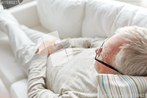 Image of close up of senior man lying on sofa