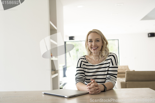 Image of Young woman with laptop at home