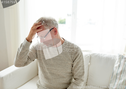 Image of senior man suffering from headache at home
