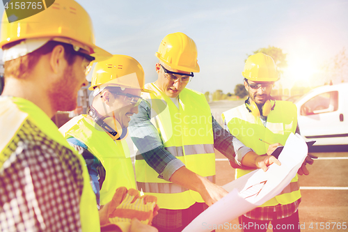 Image of group of builders with tablet pc and blueprint