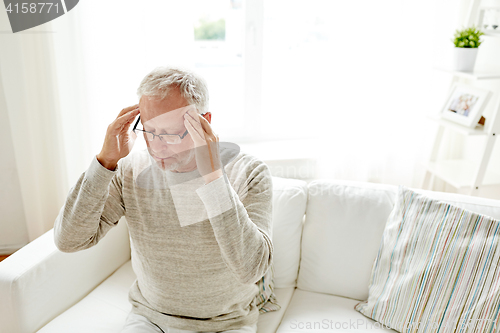 Image of senior man suffering from headache at home