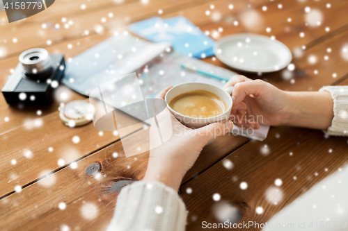 Image of close up of hands with coffee cup and travel stuff