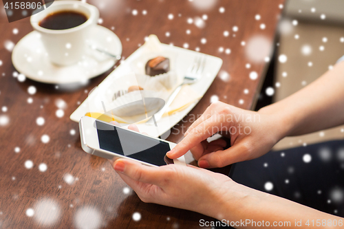 Image of close up of woman with smartphone and dessert