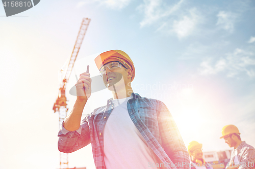 Image of builder in hardhat with walkie talkie