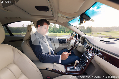 Image of Man using cell phone while driving