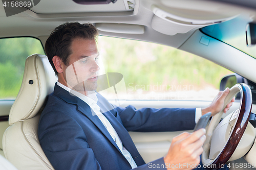 Image of Man using cell phone while driving