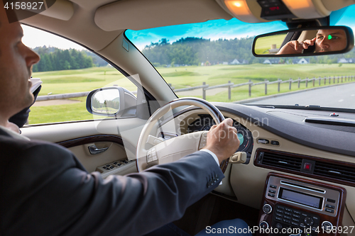 Image of Man using cell phone while driving