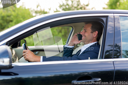 Image of Man using cell phone while driving.