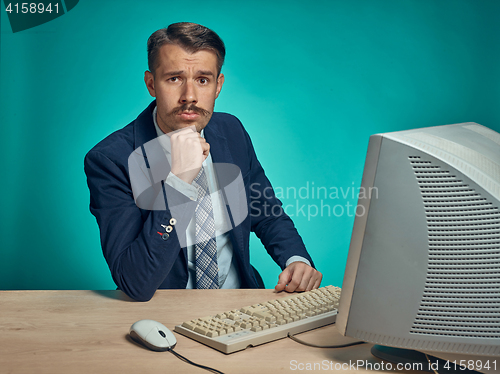 Image of Sad Young Man Working On computer At Desk