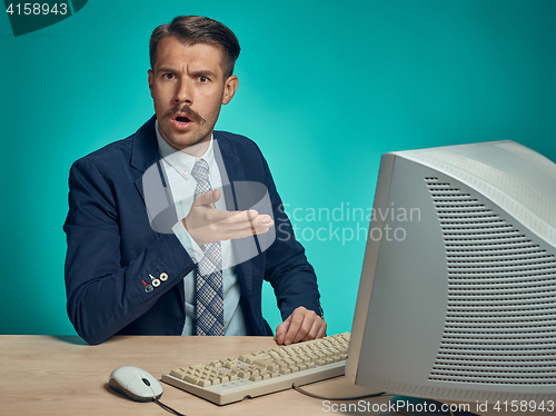 Image of Sad Young Man Working On computer At Desk