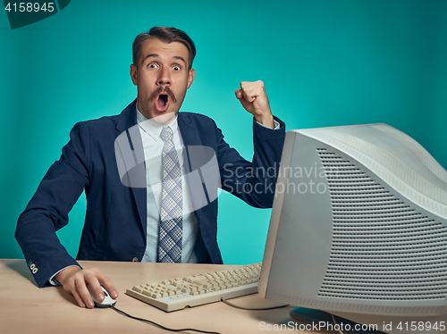 Image of Surprised Young Man Working On computer At Desk