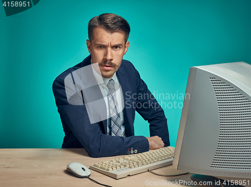 Image of Sad Young Man Working On computer At Desk