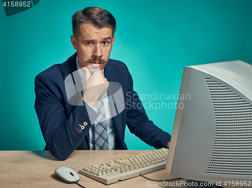 Image of Sad Young Man Working On computer At Desk