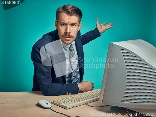 Image of Sad Young Man Working On computer At Desk