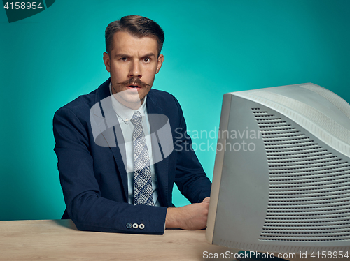 Image of Sad Young Man Working On computer At Desk