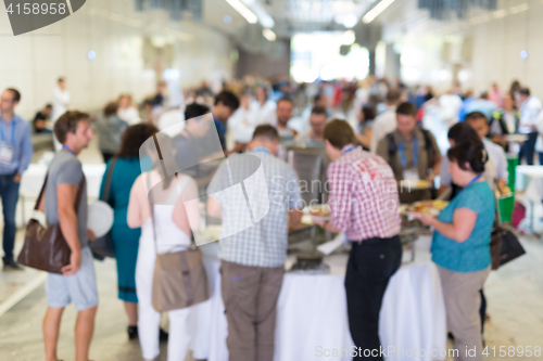 Image of Abstract blurred people socializing during lunch break at business conference.