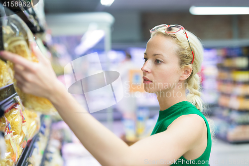 Image of Woman shopping groceries at supermarket.