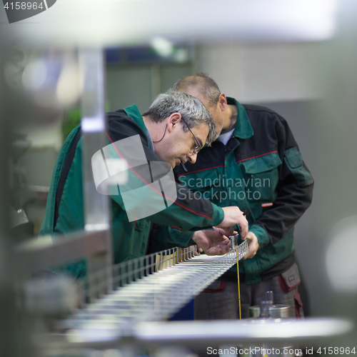 Image of Industrial worker grinding in manufacturing plant.