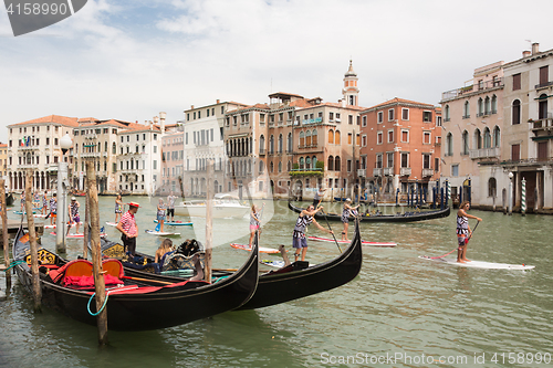 Image of Group of active tourists stand up paddling on sup boards at Grand Canal, Venice, Italy.