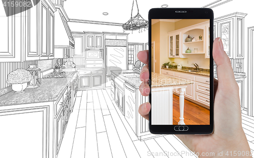 Image of Hand Holding Smart Phone Displaying Photo of Kitchen Drawing Beh