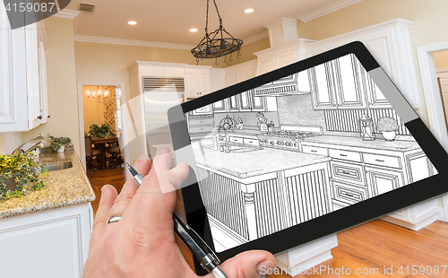 Image of Hand on Computer Tablet Showing Drawing of Kitchen Photo Behind.