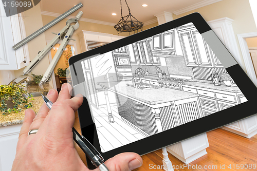 Image of Hand on Computer Tablet Showing Drawing of Kitchen Photo Behind 