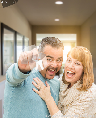 Image of Couple Holding House Keys Inside Hallway of Their New Home