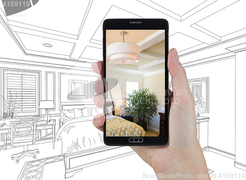 Image of Hand Holding Smart Phone Displaying Photo of Bedroom Drawing Beh
