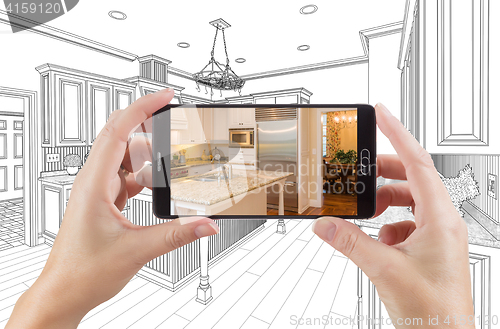 Image of Hands Holding Smart Phone Displaying Photo of Kitchen Drawing Be