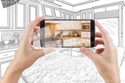 Image of Hands Holding Smart Phone Displaying Photo of Kitchen Drawing Be