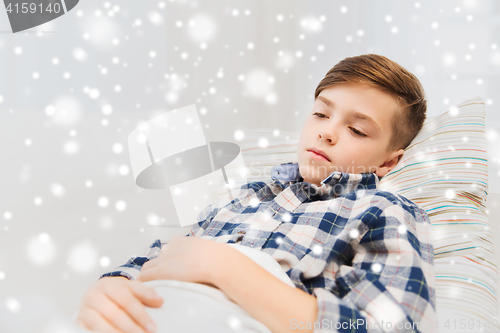 Image of ill boy with flu lying in bed at home