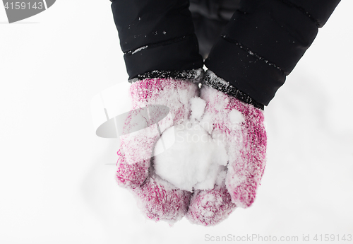 Image of close up of woman holding snowball outdoors
