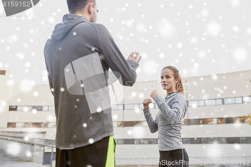 Image of woman with coach working out strike outdoors