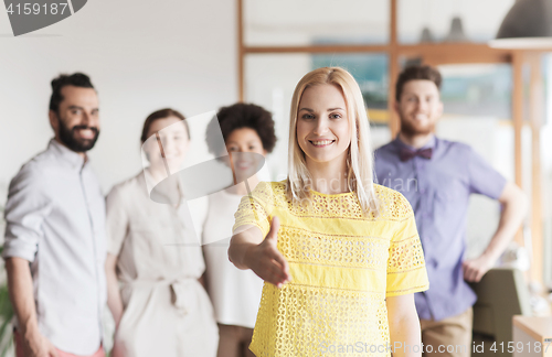 Image of woman making handshake over creative office team