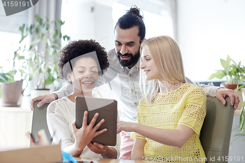 Image of happy creative team with tablet pc in office