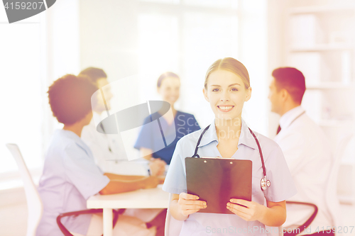 Image of happy doctor over group of medics at hospital