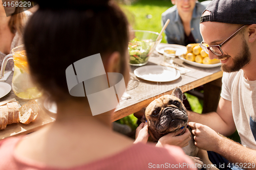 Image of happy friends having dinner at summer garden party