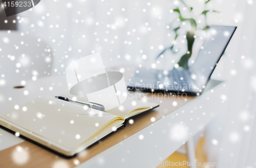 Image of notebook or diary, pen and laptop on office table