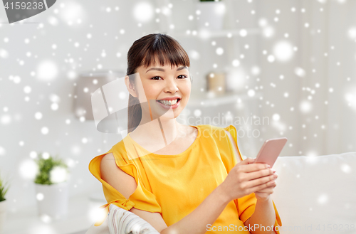 Image of happy asian woman with smartphone at home