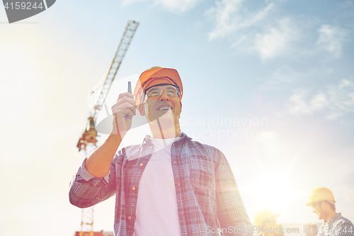 Image of builder in hardhat with walkie talkie