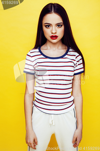 Image of young pretty teenage woman emotional posing on yellow background, fashion lifestyle people concept 