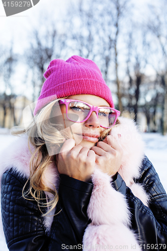 Image of young pretty teenage hipster girl outdoor in winter snow park having fun drinking coffee, warming up happy smiling, lifestyle people concept