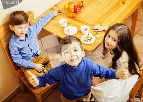 Image of little cute boys eating dessert on wooden kitchen. home interior. smiling adorable friendship together forever friends, lifestyle people concept